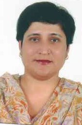 Portrait of Dr. Kapoor wearing traditional attire with academic books in background